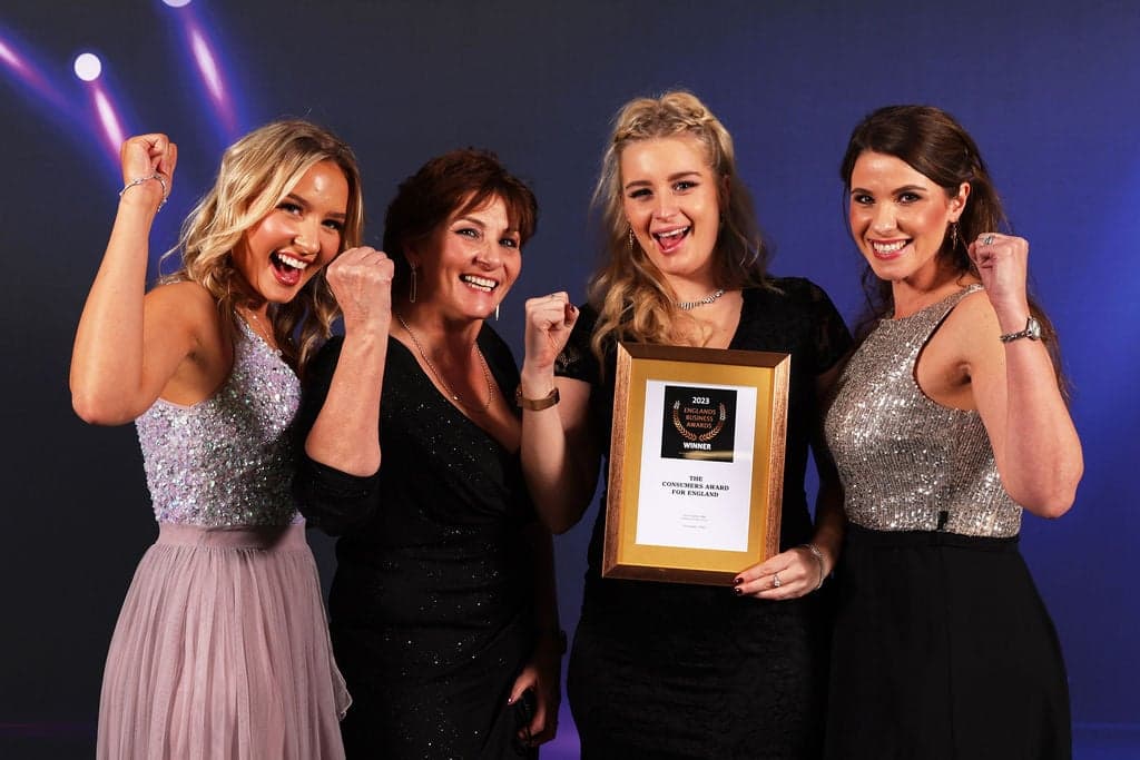 Four of the team celebrating with their 2023 England's Business Awards winner's certificate