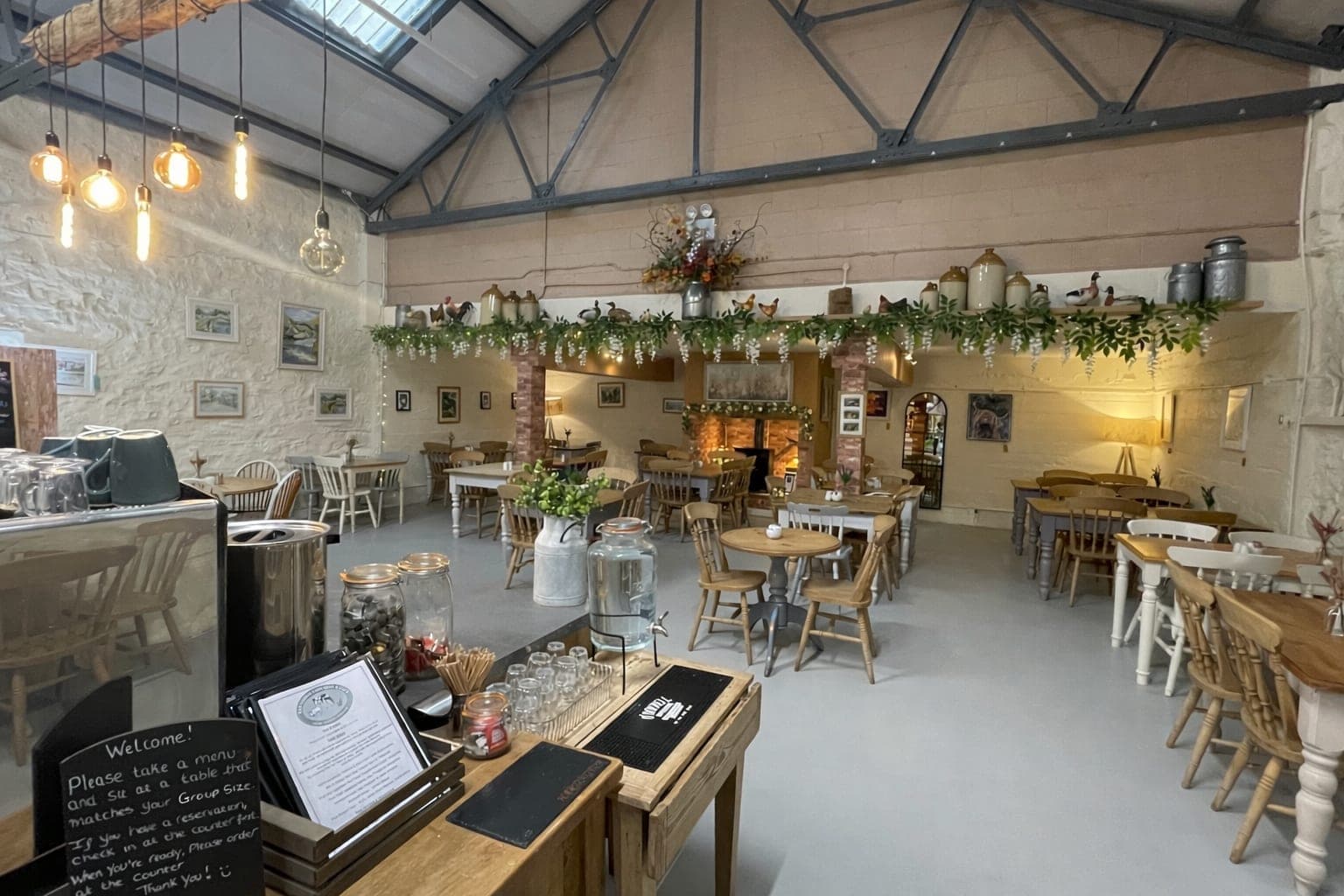 Inside the bright, airy café, with wooden tables, the counter and garlands of greenery