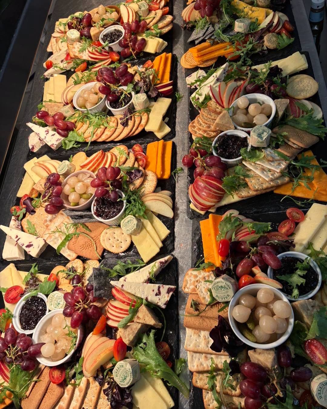 A long grazing table of meats, cheeses, fruit and bread