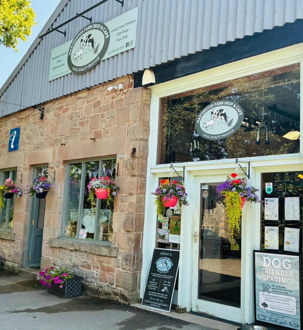 The front door of Hartington Farm Shop & Café with hanging baskets in bloom