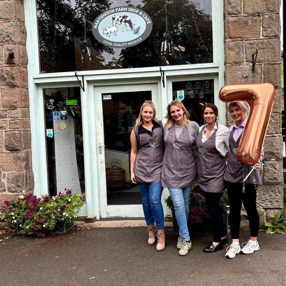 The team outside the shop celebrating with a number seven balloon